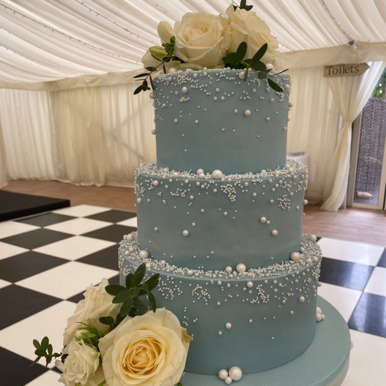 Elegant cascading pearls on pale blue three tier wedding cake Elegant cascading pearls on pale blue three tier wedding cake